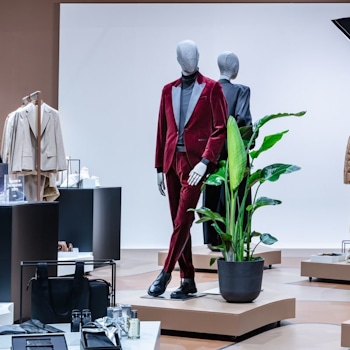 The BOSS Studio in Zurich embodies an avant-garde retail concept within a 250-square-meter space. With a nod to the brand's essence, a vibrant customisation corner and captivating window displays adorned with flashlights enchant passersby. Retail design by Studio Königshausen.